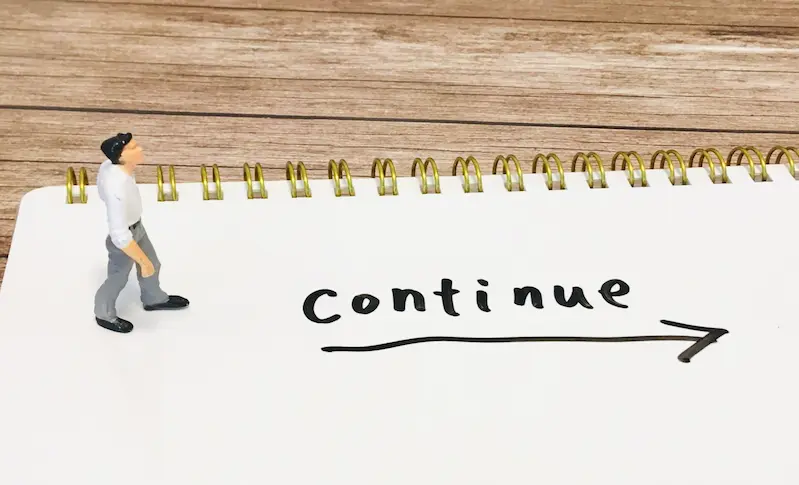 男性がコンティニューと書かれた場所を歩いている