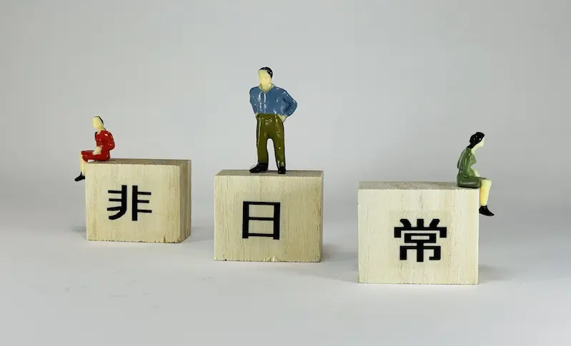 非日常と書かれたブロックに人形が立っている